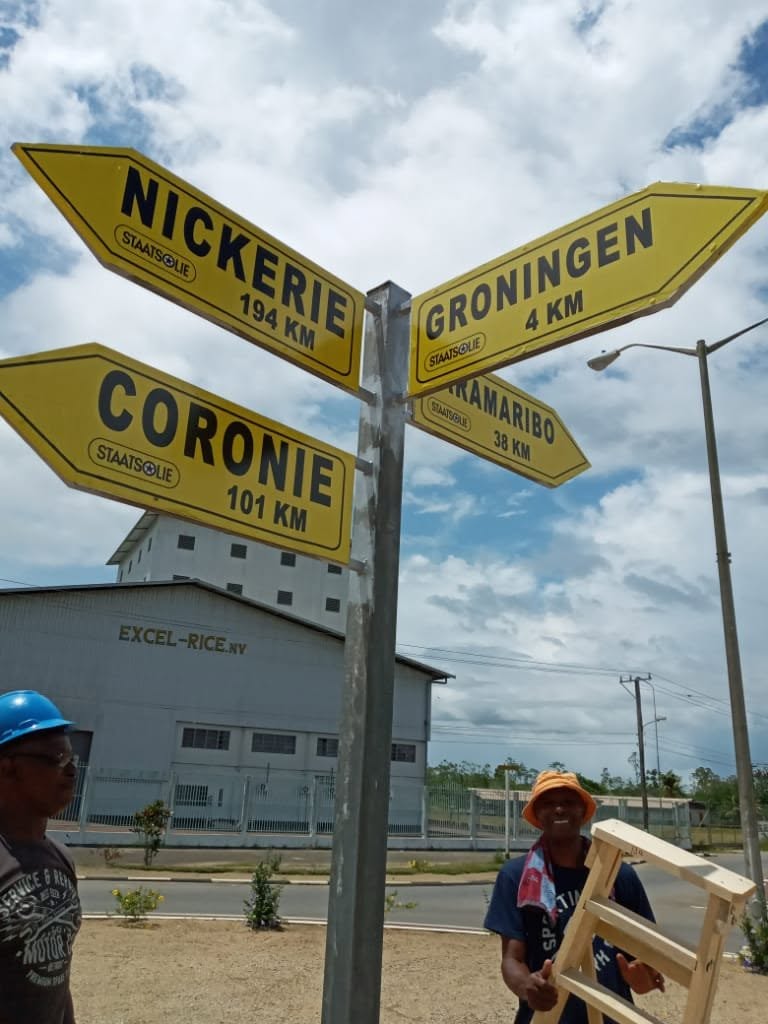 Reclamewerk bij de wegwijzers van Nickerie en Coronie